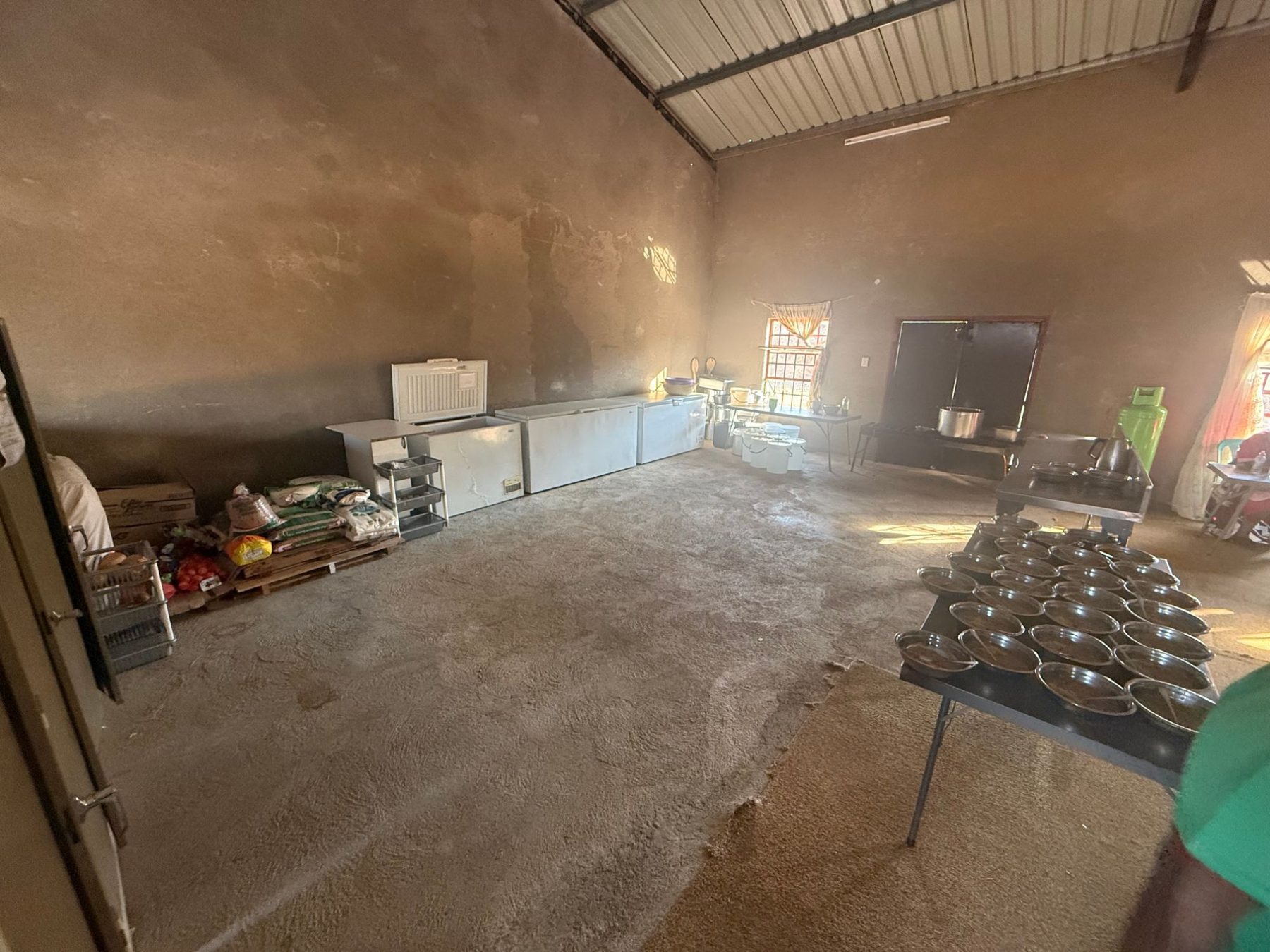 The care centre kitchen with chest freezers, sacks of maize and vegetables